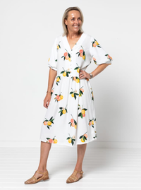 Woman wearing the Porter Woven Pack sewing pattern from Style Arc on The Fold Line. A dress pattern made in cotton, rayon, crepe, or washed linen fabric, featuring a v neck, button front bodice, mid-length sleeves, low waist, gathered skirt, in-seam pocke