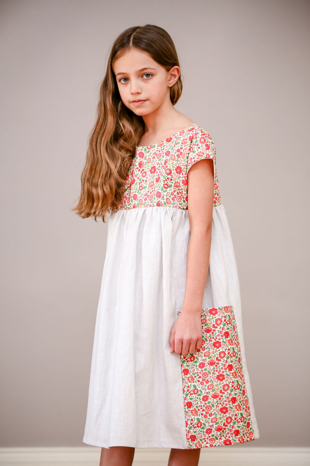 Child wearing the Children's Portobello Pocket Dress sewing pattern by Greyfriars and Grace. A dress pattern made in cotton, linen or cotton/linen blend fabric for dress and lining, featuring a relaxed fit, two large side pockets and a button back closure