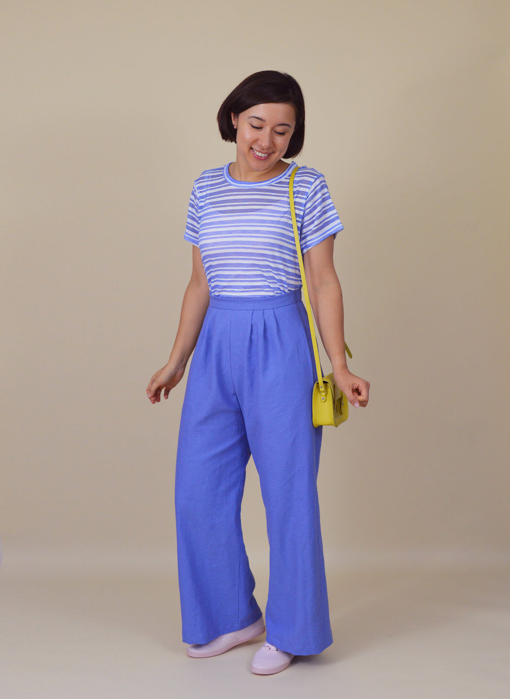 Woman wearing the Portobello Trousers sewing pattern from Nina Lee on The Fold Line. A trouser pattern made in crepe, linen, chambray, rayon, lightweight wool, cotton lawn or velvet fabrics, featuring a high waist, wide-legged silhouette, front pleats, ba