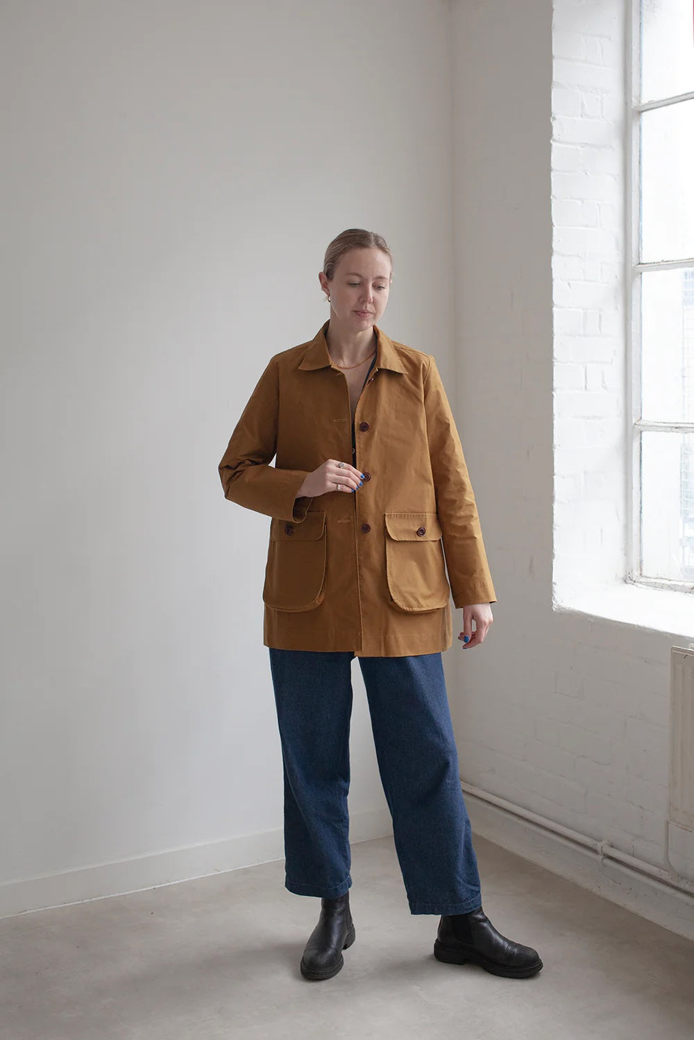 Woman wearing the Potters Jacket sewing pattern from The Modern Sewing Co. on The Fold Line. A jacket pattern made in waxed cottons, wools, denims, cotton canvas, linens or hemp fabrics, featuring a two-piece sleeve, collar, pockets, full length sleeves, 