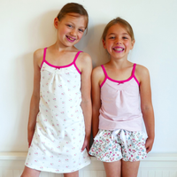 Children wearing the Child/Teen Pow Tank Top or Dress sewing pattern from Petits D’om on The Fold Line. A tank top and dress pattern made in jersey fabrics, featuring thin shoulder straps, rounded yoke with gathers, back neckline is straight, slight A-lin