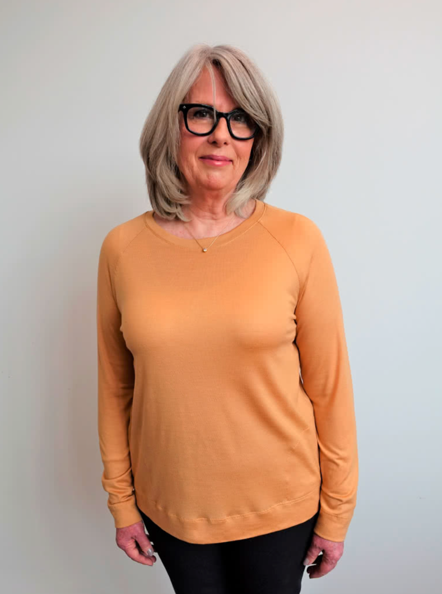 Woman wearing the Preston Knit Sweater sewing pattern from Style Arc on The Fold Line. A jumper pattern made in knit jersey or baby wool fabrics, featuring a squarish silhouette, crew neck, raglan sleeves and in-seam pockets.