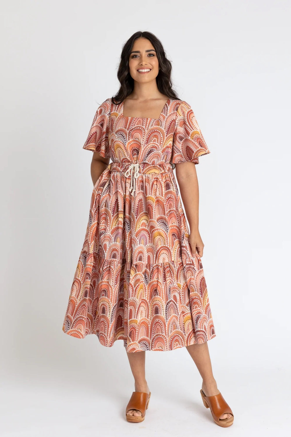 Woman wearing the Protea Dress sewing pattern from Megan Nielsen on The Fold Line. A dress pattern made in cotton, shirting, voile, batiste, lawn, silk, crepe, rayon, chambray or linen fabrics, featuring a square neckline, flutter sleeves, tiered gathered