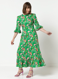 Woman wearing the Queenie Woven Dress sewing pattern from Style Arc on The Fold Line. A dress pattern made in silk, rayon, or charmeuse fabric, featuring a darted fitted bodice, centre back zip, elbow length sleeve with a double frill and gathered head, a