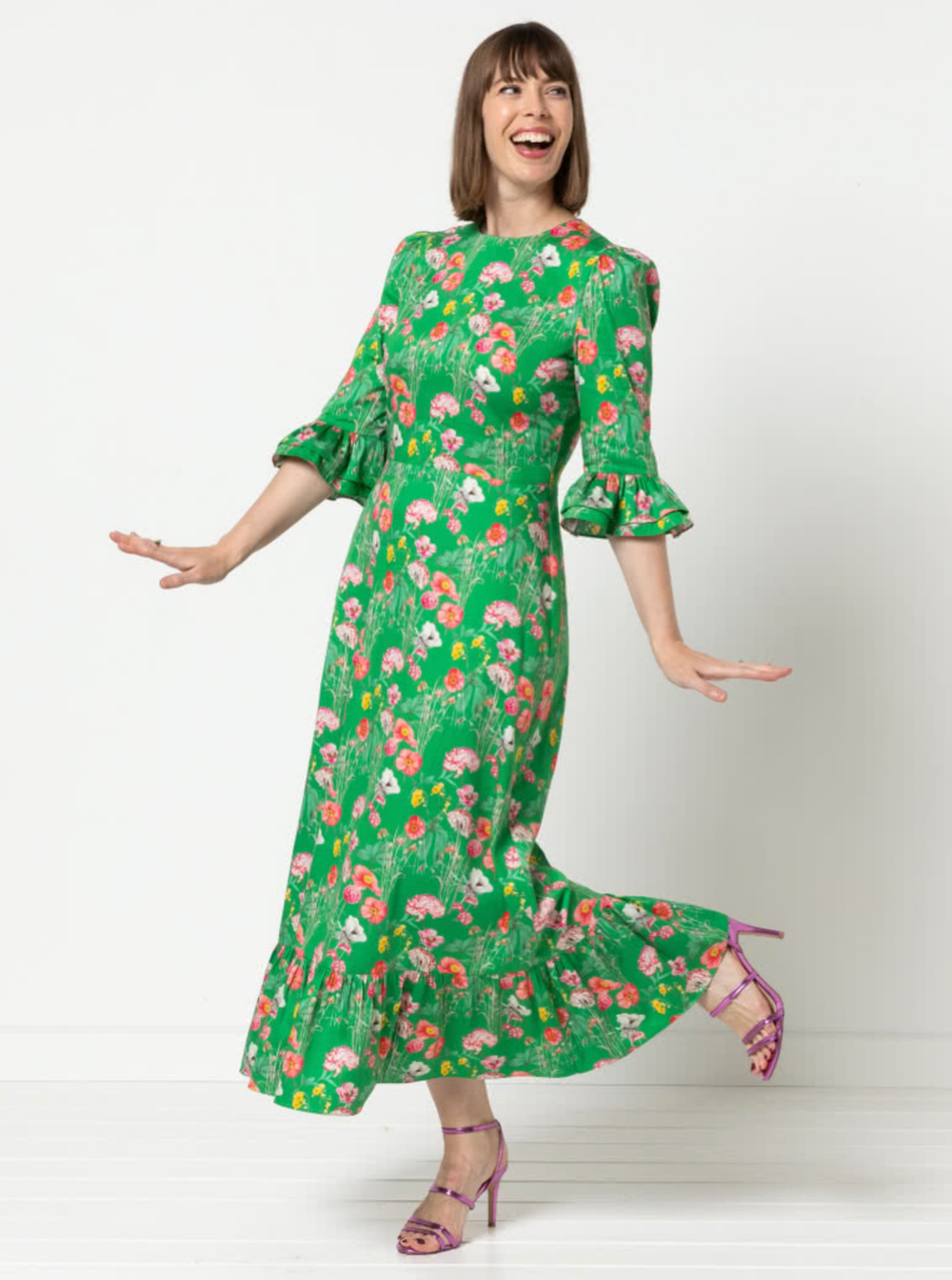 Woman wearing the Queenie Woven Dress sewing pattern from Style Arc on The Fold Line. A dress pattern made in silk, rayon, or charmeuse fabric, featuring a darted fitted bodice, centre back zip, elbow length sleeve with a double frill and gathered head, a