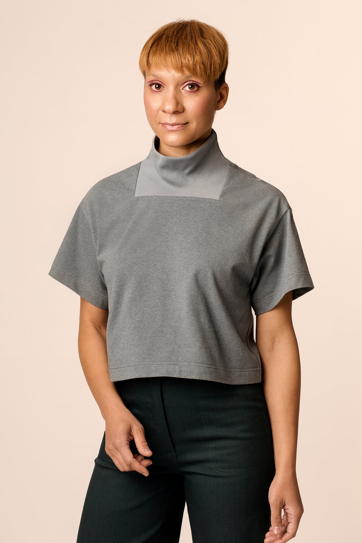 Woman wearing the Rauha Tee sewing pattern from Named on The Fold Line. A T-shirt pattern made in knit fabrics, featuring a hip length boxy fit, rectangular ribbed funnel neck, dropped shoulders and a relaxed fit.