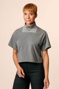 Woman wearing the Rauha Tee sewing pattern from Named on The Fold Line. A T-shirt pattern made in knit fabrics, featuring a hip length boxy fit, rectangular ribbed funnel neck, dropped shoulders and a relaxed fit.