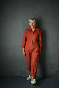 Woman wearing the Thelma Boilersuit sewing pattern from Merchant and Mills on The Fold Line. A boilersuit pattern made in twill, denims, linens or cotton poplin fabrics, featuring a loose fit, front and back patch pockets, front pockets, back yoke, two pi