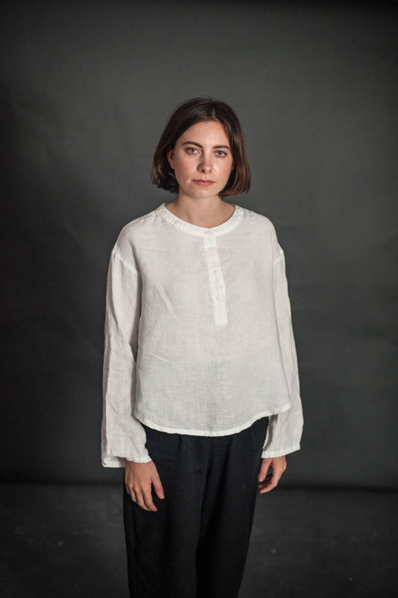 Woman wearing the Swing Top sewing pattern by Merchant and Mills. A loose fitting top pattern made in linen, cotton, or tencel fabric featuring dropped shoulders, Henley neck, button placket and long sleeves.