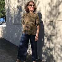 Woman wearing the Rae Top sewing pattern from Tessuti Fabrics on The Fold Line. A blouse pattern made in linen, cotton poplin, lightweight wool, lightweight denim, silk, viscose and rayon fabrics, featuring a relaxed fit, wide gathered neckline, and elbow