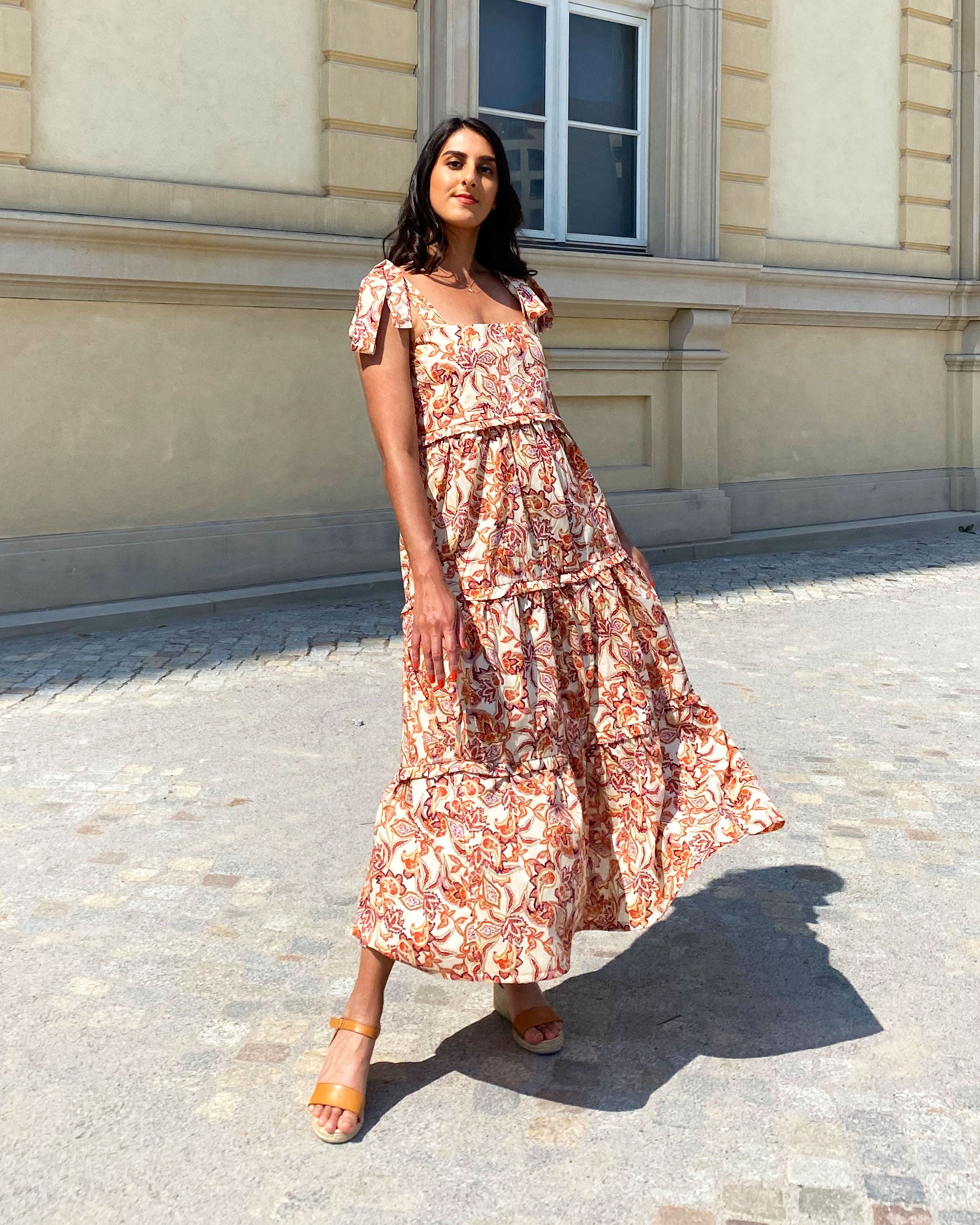 Woman wearing the Raman Dress sewing pattern from Tammy Handmade on The Fold Line. A slip-on dress pattern made in cotton, satin, cotton poplin, rayon/viscose, crepe or chiffon fabric, featuring long tie shoulder straps, square neckline, three-tiered skir