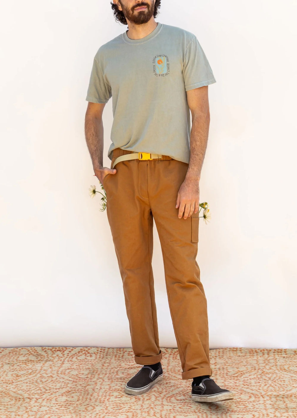 Man wearing the Men’s Rambler Pants sewing pattern from Friday Pattern Company on The Fold Line. A pull-on pants pattern made in denim, twill, or canvas fabric, featuring a relaxed fit, elastic waist with a built-in belt, faux fly, side and patch pockets,