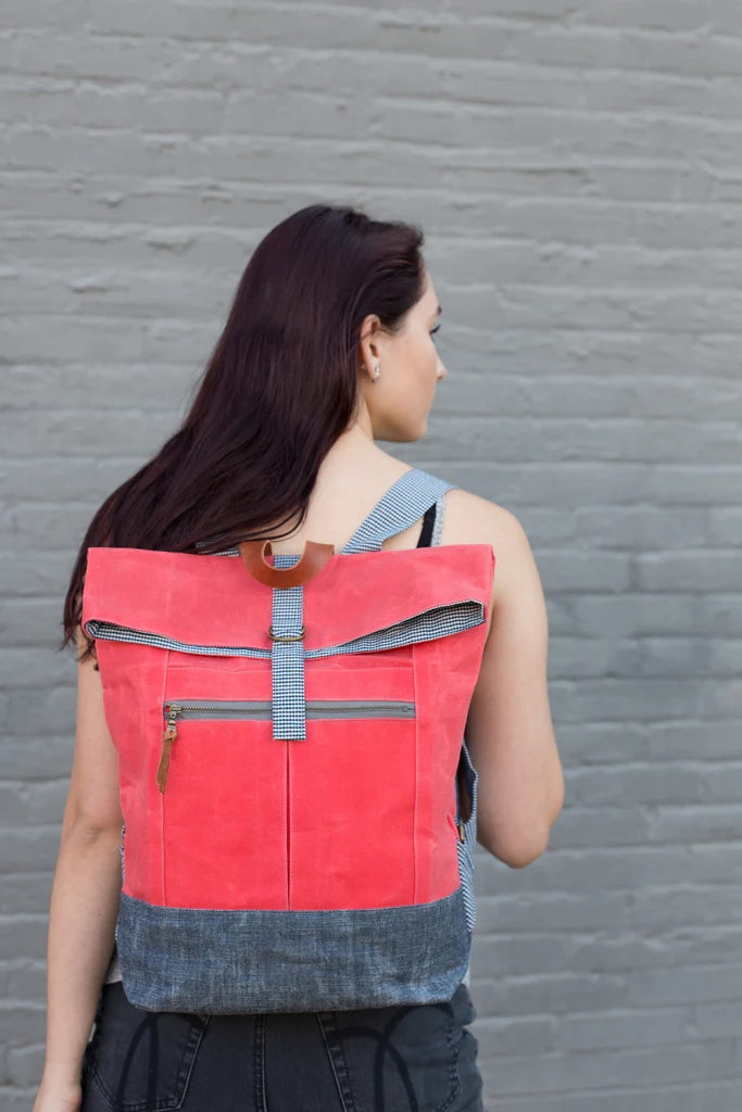 Woman wearing the Range Backpack sewing pattern from Noodlehead on The Fold Line. A backpack pattern made in waxed canvas, cotton cancas, cotton/linen canvas, denim or cork fabrics, featuring a foldover top, front zippered pocket, adjustable straps, inter