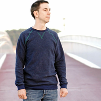 Man wearing the Men's Rebel Raglan sewing pattern from Wardrobe by Me on The Fold Line. A sweatshirt pattern made in heavy French terry or sweatshirt fabrics, featuring a crew neckline, front triangle detail, raglan sleeves, rib cuffs and hem band.