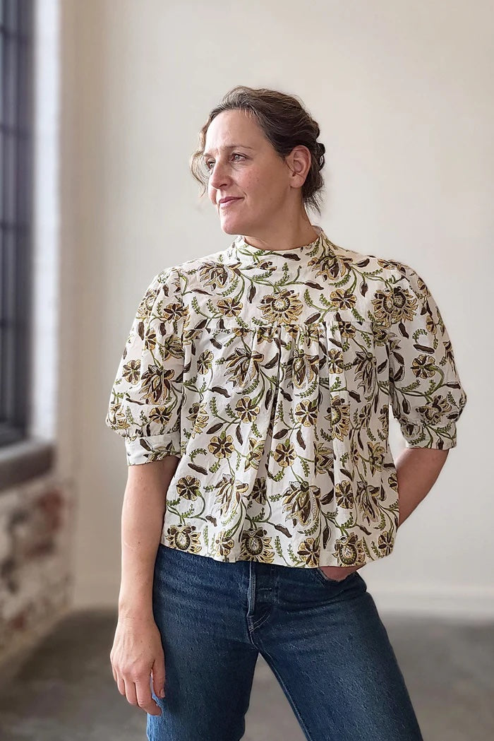 Woman wearing the Regalia Blouse sewing pattern from Sew House Seven on The Fold Line. A blouse pattern made in all cottons and lightweight linen fabrics, featuring a roomy fit, gathered front and back yokes, pull on style, back keyhole opening with ties,