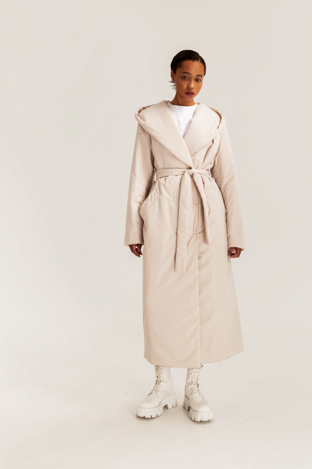 Woman wearing the Reggie Coat sewing pattern from Vikisews on The Fold Line. A puffer coat pattern made in blended raincoat fabrics, outerwear fabrics, or Dewspo fabrics, featuring a loose fit, straight cut, welt pockets, grown-on hood, bust darts, long l