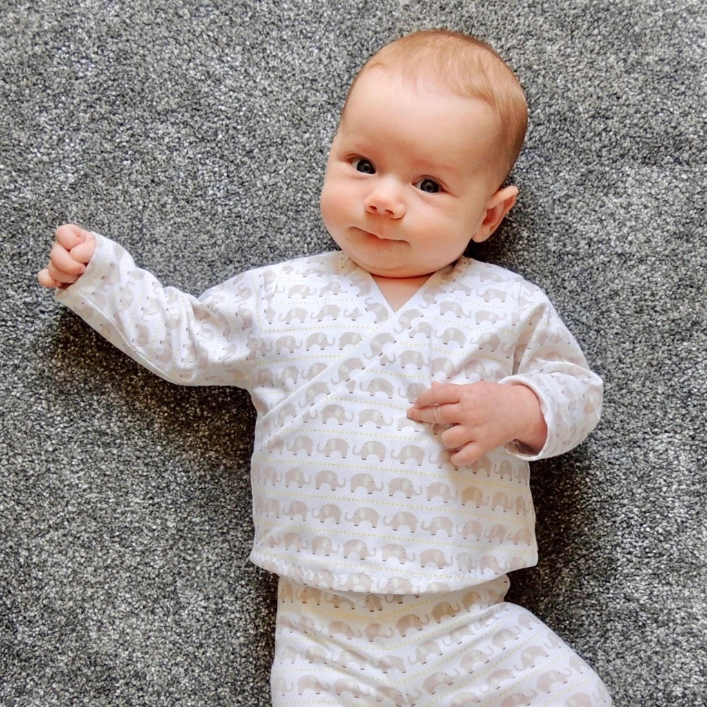 Baby wearing the Babies' Roo Top and Marley Bottoms sewing pattern from Dhurata Davies Patterns on The Fold Line. A top and pants pattern made in lightweight cotton jersey fabrics, featuring trousers with knit waistband and full length leg. Top with a fau