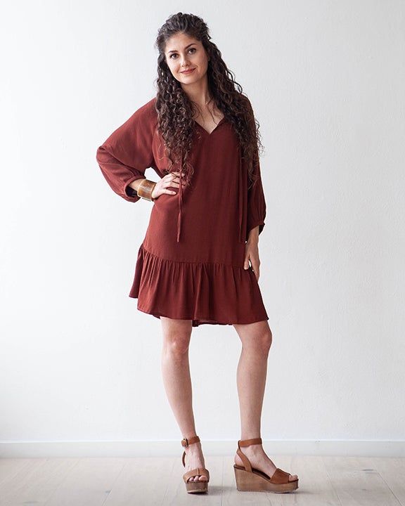 Woman wearing the Roscoe Dress sewing pattern by True Bias. A boho-inspired dress pattern made in rayon crepe, cotton voile, silk, lightweight linen or gauze fabric featuring a large bottom hem ruffle, raglan sleeves, gathered neckline, the neckline is fi