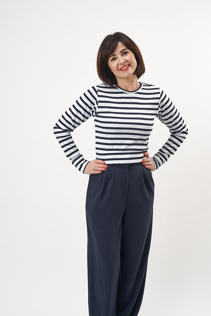 Woman wearing the Roxy Jumper sewing pattern from Sew Over It on The Fold Line. A knit top pattern made in light to medium weight knit fabrics such as cotton jersey, French terry or ponte di roma fabrics, featuring long sleeves, round neck, and close fitt