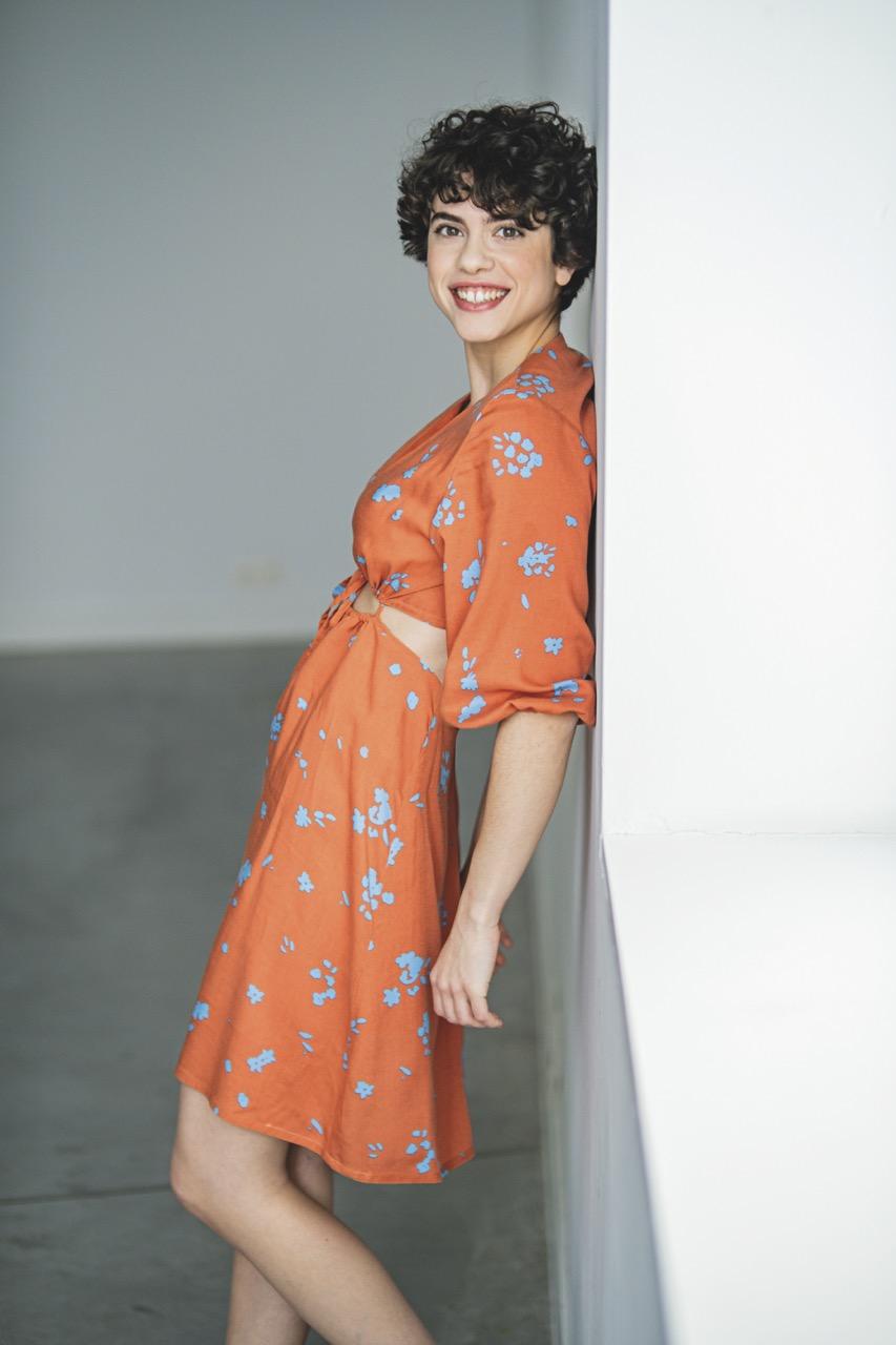 Woman wearing the Ruba Dress sewing pattern from Fibre Mood on The Fold Line. A dress pattern made in lyocell, chambray, linen, viscose (crêpe), mousseline, broderie anglaise and modal fabrics, featuring a front and back waist cut-out, deep V-neck, slight