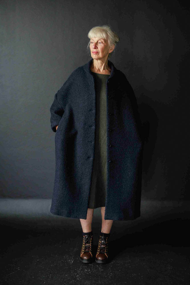 Woman wearing the Sanda Coat sewing pattern from Merchant & Mills on The Fold Line. A coat pattern made in dry oilskin, oilskin, linen, denim, wool, corduroy, cotton twill or canvas fabrics, featuring an oversized fit, rolled collar, turn back cuffs, in-s