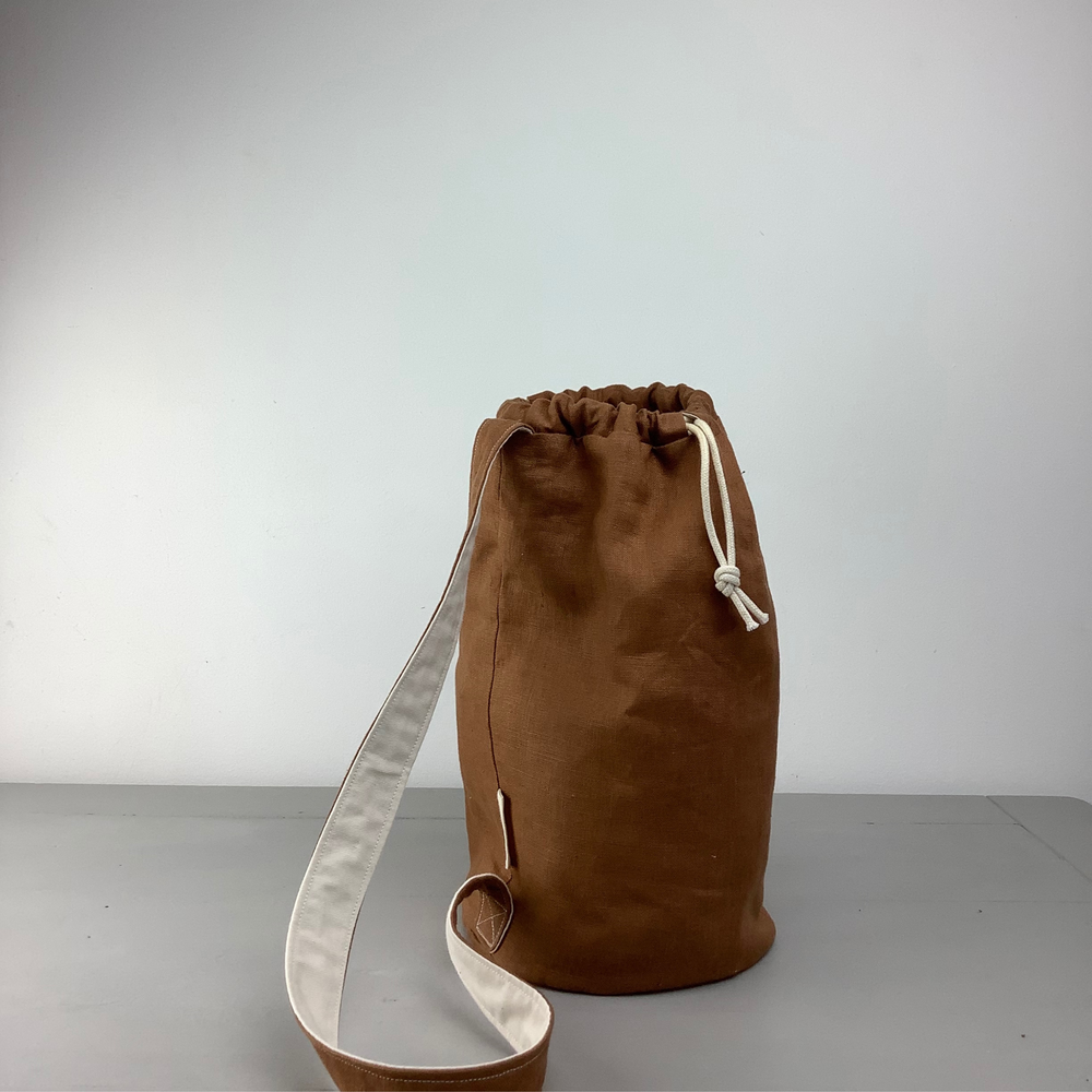 Photo showing the Samphire Duffle Project Bag sewing pattern from Lasenby on The Fold Line. A drawstring bag pattern made in canvas, linen, quilting cotton, twill, duck, denim, thin tweed, and Tana lawn fabrics, featuring inside customisable pockets, loop