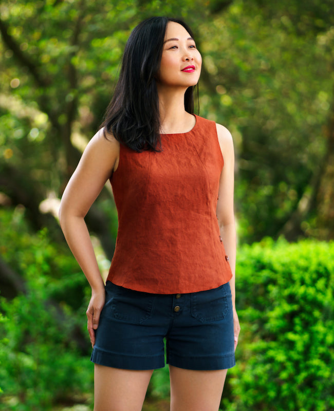 Woman wearing the Santorini Tank sewing pattern from Itch to Stitch on The Fold Line. A tank pattern made in linen, chambray, broadcloth and plain weave cotton fabrics, featuring a semi-fit, princess seams, high hip length, neckline and armholes facings, 