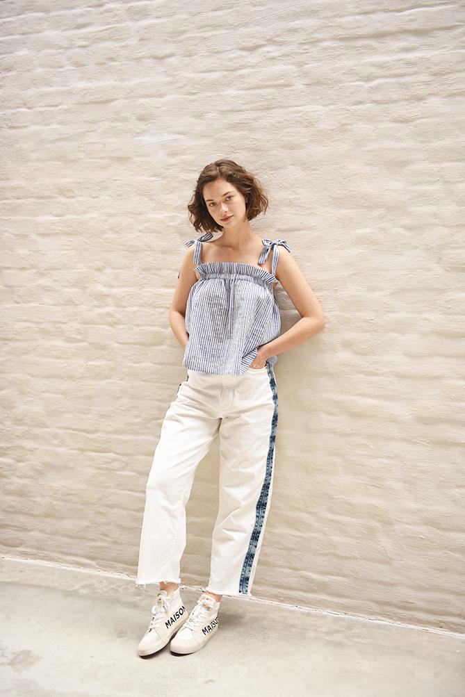 Woman wearing the Sara Top sewing pattern from Fibre Mood on The Fold Line. A sleeveless top pattern made in linen, cotton, (viscose) crêpe or chiffon fabrics, featuring a straight silhouette, elastic at the top creating a ruffled effect and shoulder ribb