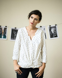 Woman wearing the Helsinki Blouse sewing pattern from Orageuse on The Fold Line. A blouse pattern made in viscose, cotton, silk, crepe or poplin fabrics, featuring a very loose fit, front twist detail, long sleeves with buttoned cuffs, deep V-neck, thin c
