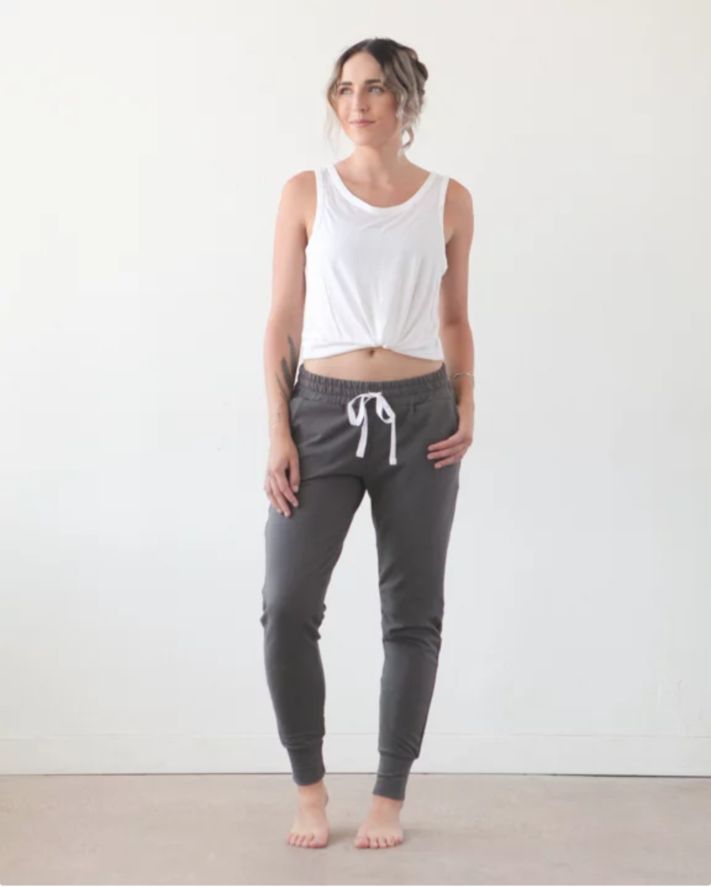 Woman wearing the Hudson Pant sewing pattern by True Bias. A jogger sweatpant pattern made in cotton lycra, French terry, ponte or sweatshirt knit fabric featuring an urban fit with extra room around the hips and then tapers into a skinny leg, elastic wai