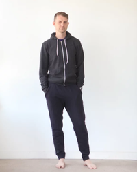 Man wearing the Men’s Hudson Pant sewing pattern by True Bias. A modern sweatpant pattern made in French terry, ponte or sweatshirt knit fabric featuring an elastic waist with drawstring, front pockets, a tapered leg with a cuff at the ankle.