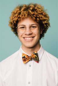 Man wearing the Ola Bow Tie sewing pattern from Melilot on The Fold Line. A bow tie pattern made in cotton, wool, silk or rayon fabrics, featuring a reversible style.