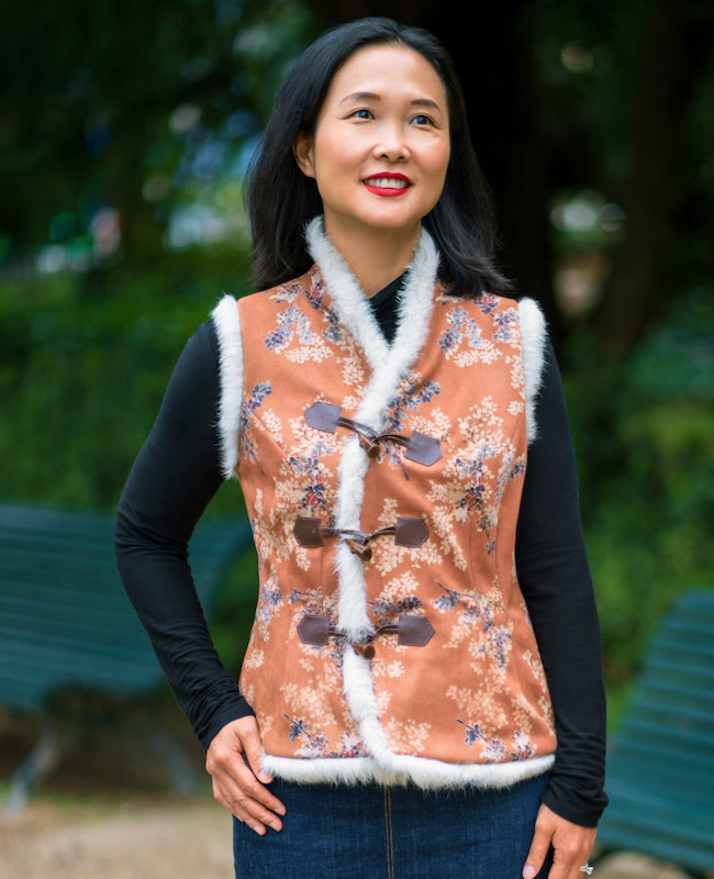 Woman wearing the Shau Vest sewing pattern from Itch to Stitch on The Fold Line. A vest/gilet pattern made in brocade, jacquard, twill, broadcloth, chambray, linen, wool blend, ponte, or scuba fabrics, featuring an asymmetric front toggle closure, waist a