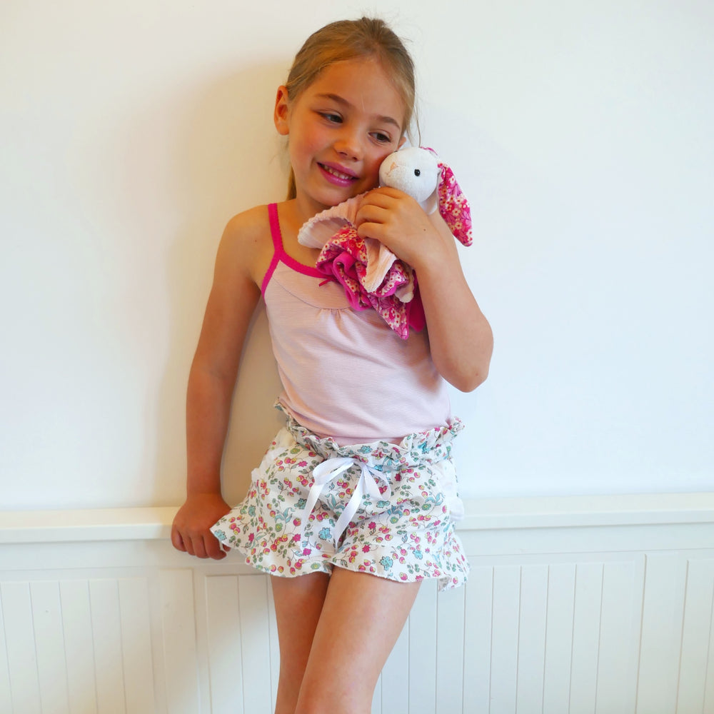 Child wearing the Child/Teen Sheebam Shorts or Pants sewing pattern from Petits D’om on The Fold Line. A PJ pants or shorts pattern made in fine cotton, cotton satin, Liberty, viscose, light chambray, batiste, tencel or double gauze fabrics, featuring a p