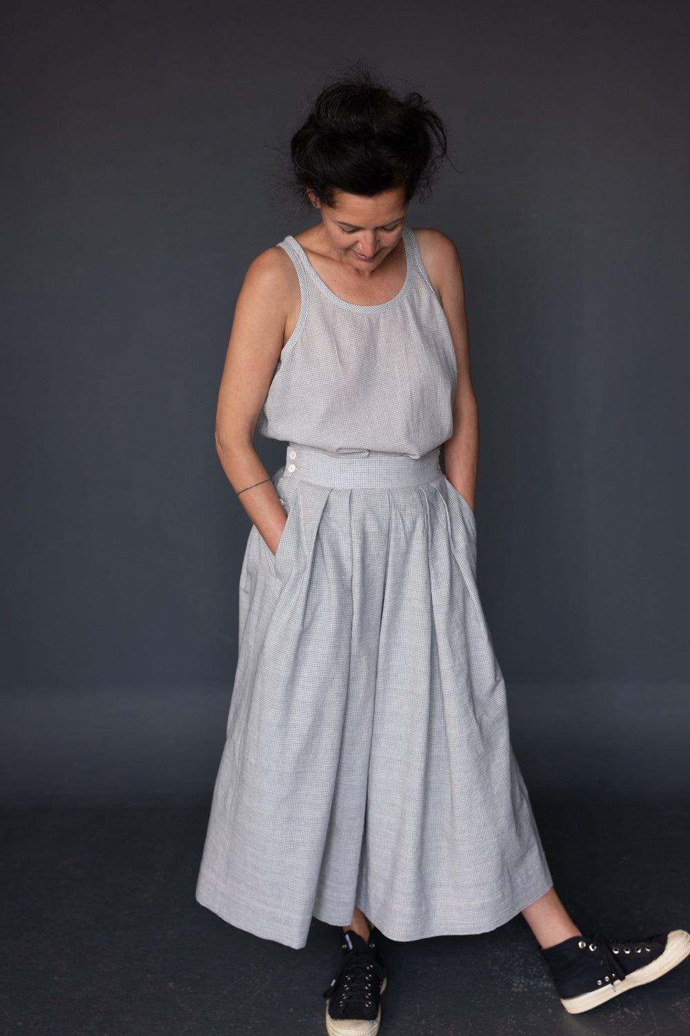 Woman wearing the Shepherd Skirt pattern from Merchant and Mills on The Fold Line. A pleated shirt pattern made in linen, cottons, hemp blends, tencel/linen, needlecord, denim, lightweight wool or Indian handlooms fabrics, featuring an A-line silhouette, 