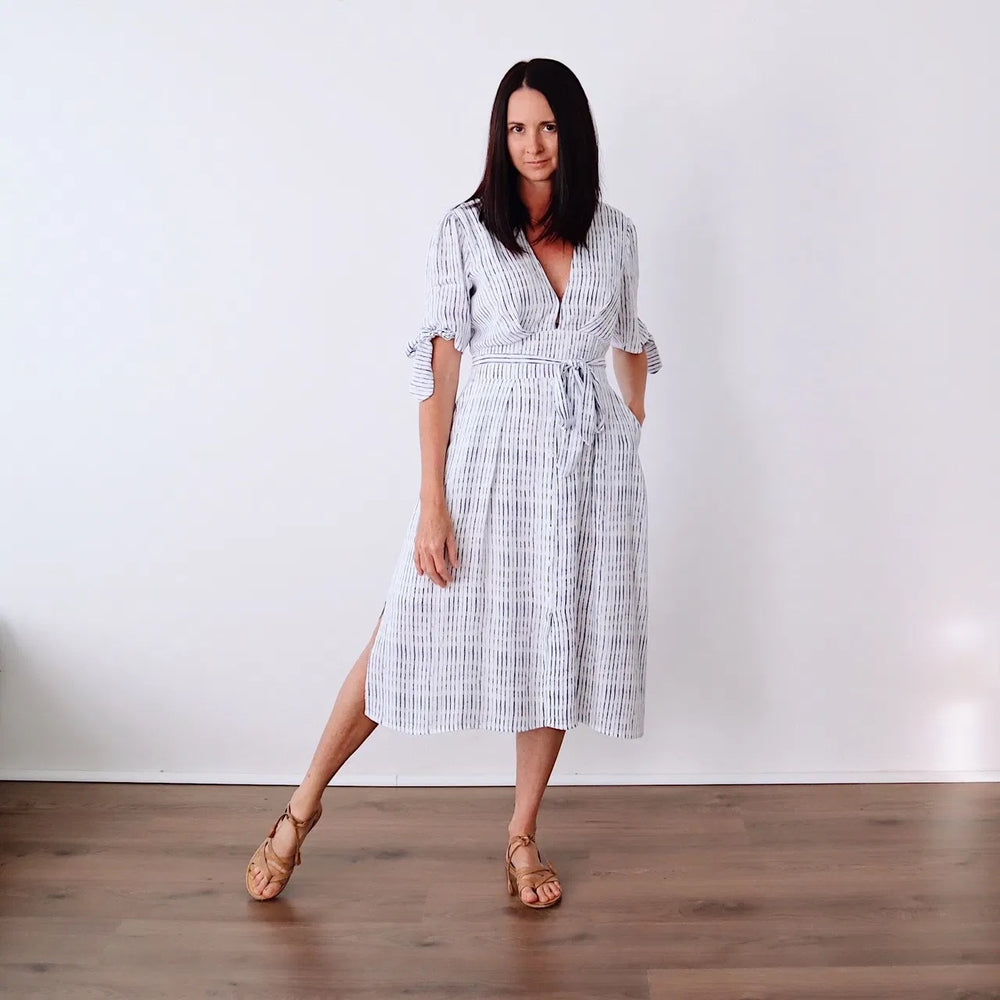 Woman wearing the Sia Dress sewing pattern from Marsha Style on The Fold Line. A slip dress pattern made in linen, linen blends, cotton, cotton gauze, viscose, rayon or silk fabrics, featuring a midi length, low V-neck, bust pleats, back bodice darts, sha