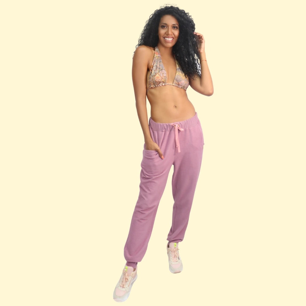 Woman wearing the Silma Joggers sewing pattern Sirena Patterns on The Fold Line. A joggers pattern made in French terry, cotton/spandex, interlock or double knit fabrics, featuring a loose fit, elastic and drawstring waist, front pockets and ankle ribbing