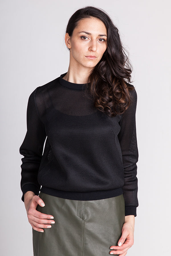 Woman wearing the Sloane Sweatshirt sewing pattern from Named on The Fold Line. A sweatshirt pattern made in sweatshirt jersey, terry, teddy or light neoprene fabrics, featuring a straight cut but semi-loose fit, long diagonal bust darts, round neck, ribb
