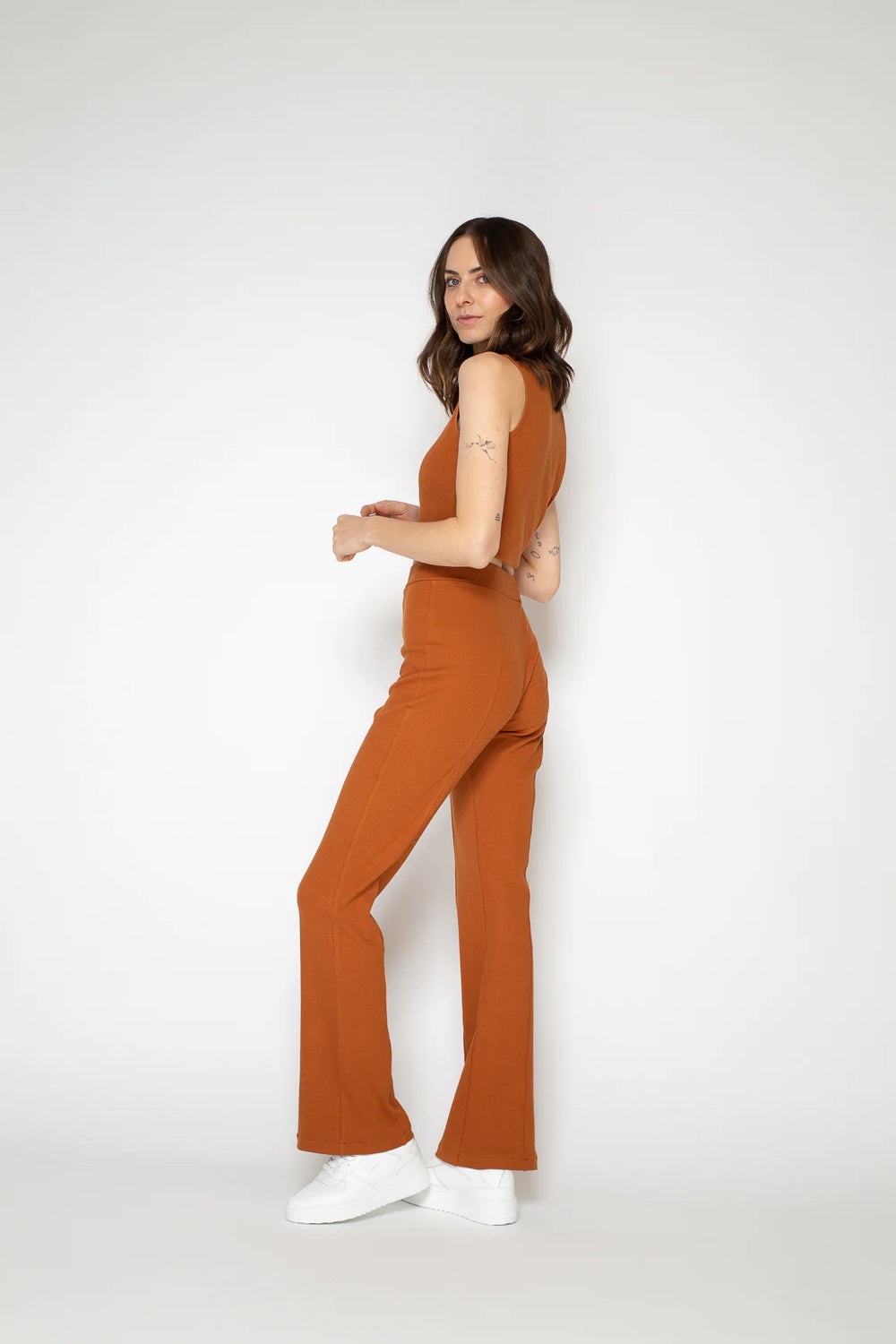 Woman wearing the Smilla Flared Pants sewing pattern from Bara Studio on The Fold Line. A trouser pattern made in knit fabrics, featuring a close-fit, high waistband, and flared legs.