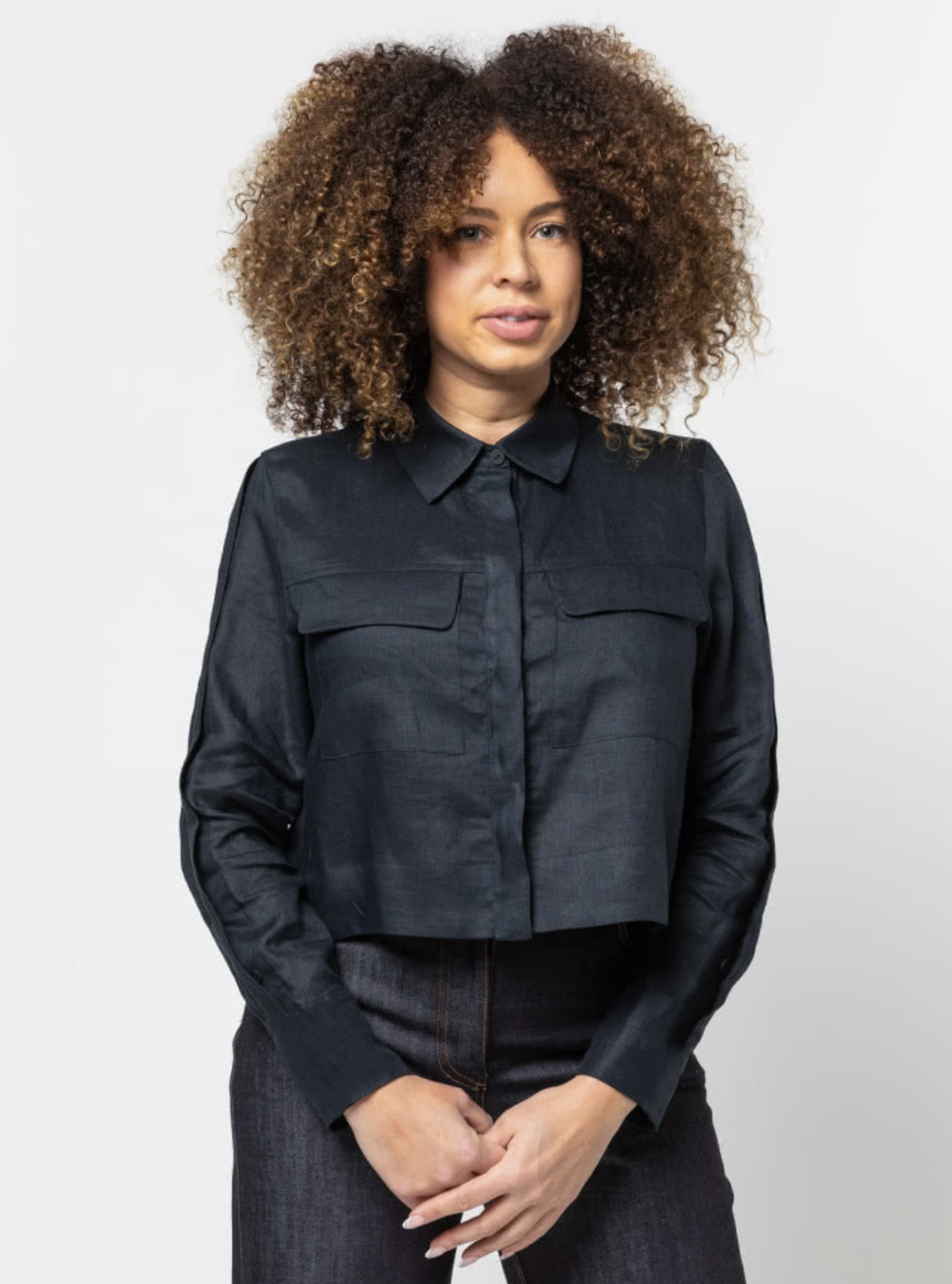 Woman wearing the Smith Woven Jacket sewing pattern from Style Arc on The Fold Line. A jacket pattern made in linen, cotton, silk, crepe, or rayon fabrics, featuring a cropped length, button-front closure, two-piece collar, front and back yokes, back plea