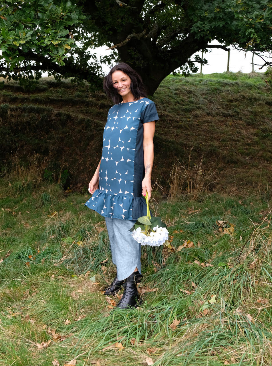Woman wearing the Solis Tunic sewing pattern from Sew Different on The Fold Line. A shift dress pattern made in cotton, linen, viscose, silk or chambray fabrics, featuring cap sleeves, relaxed fit, round neck, knee length finish and integrated side panels