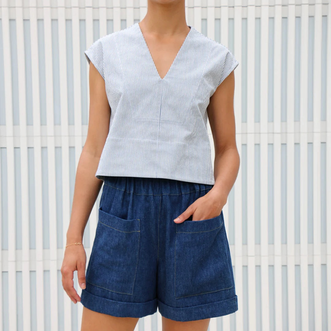 Woman wearing the Sonia Shorts sewing pattern from Tessuti Fabrics on The Fold Line. A shorts pattern made in cotton, linen, linen blends, or medium weight chambray fabric, featuring a relaxed and comfortable fit, wide leg, high waist with elastic and a p