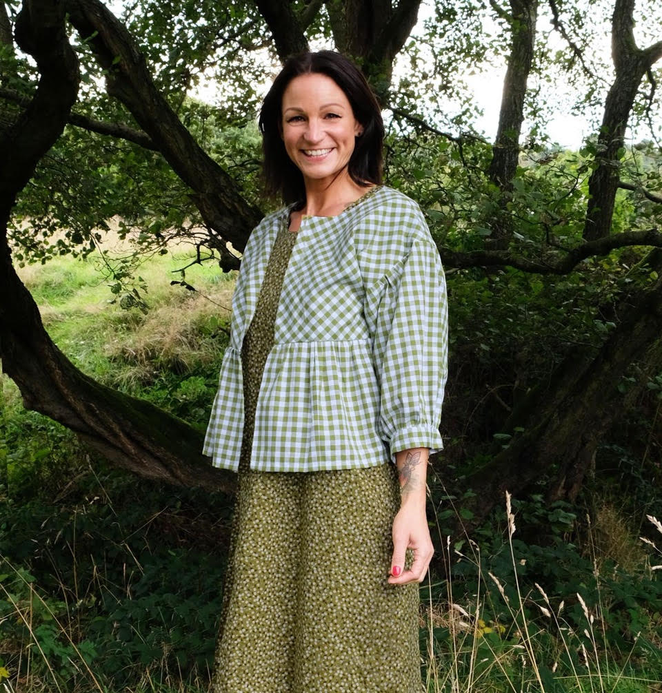 Woman wearing the Stella Blouson sewing pattern from Sew Different on The Fold Line. A blouse pattern made in cotton, linen, raw silk, denim, denim or velvet fabrics, featuring drop shoulders, hook and eye fastening, gathers under the bust and gentle ball