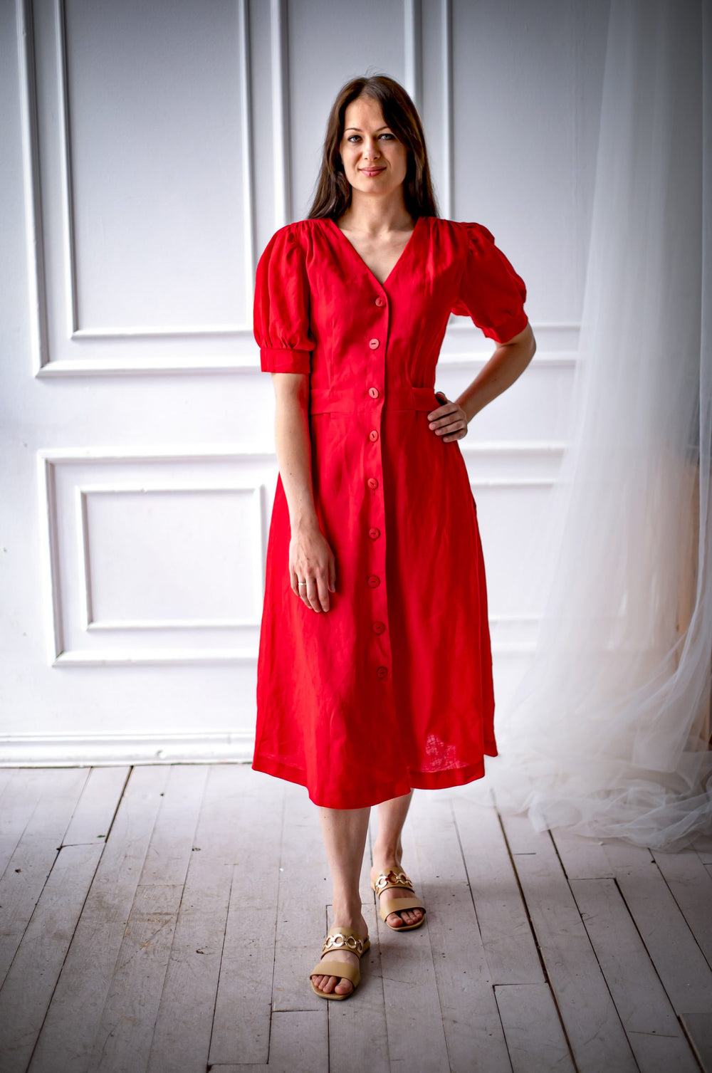 Woman wearing the Stella Dress sewing pattern from Kates Sewing Patterns on The Fold Line. A dress pattern made in cotton, linen or silk fabrics, featuring shoulder gathers, short voluminous sleeves with gathers at the top and bottom, below knee length fl