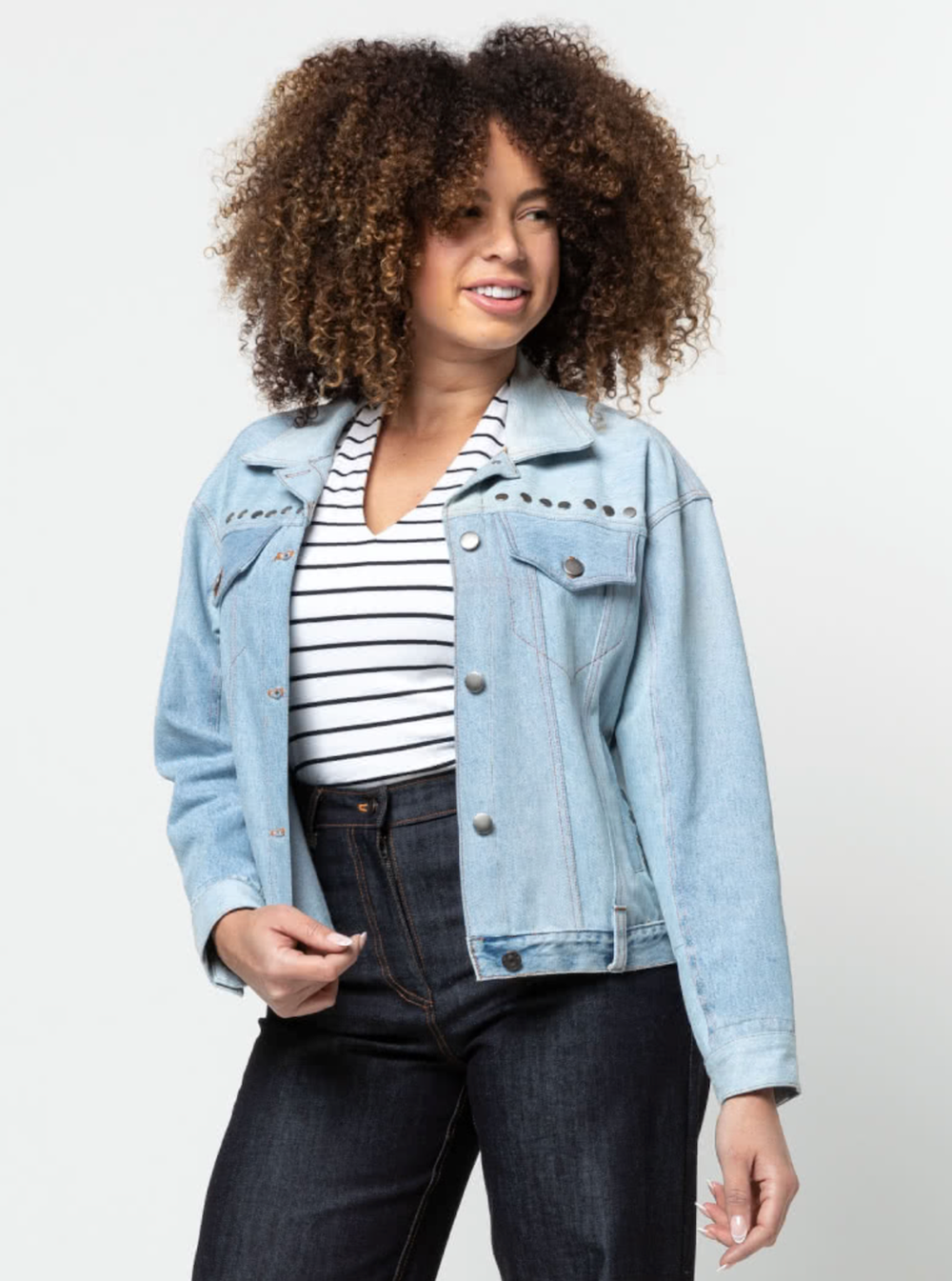 Woman wearing the Stevie Jean Jacket sewing pattern from Style Arc on The Fold Line. A denim jacket pattern made in denim, drill, or linen fabrics, featuring front chest pockets with flaps, side pockets, collar with stand, front and back yoke, full length