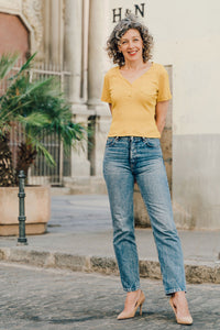 Woman wearing the Strasbourg Henley Top sewing pattern from Liesl + Co on The Fold Line. A top pattern made in jersey fabrics, featuring a close-fit, pullover V-neck, three button front placket, cropped length, small chest pocket and short sleeves.