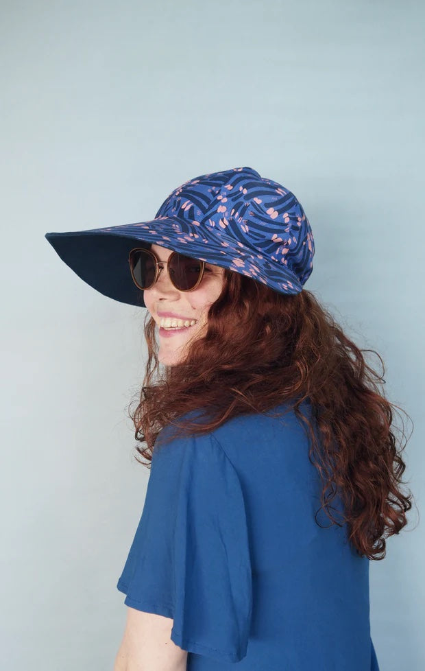 Woman wearing the Sunni Hat sewing pattern from Melilot on The Fold Line. A hat pattern made in linen or cotton fabrics featuring a broad peak with full coverage.