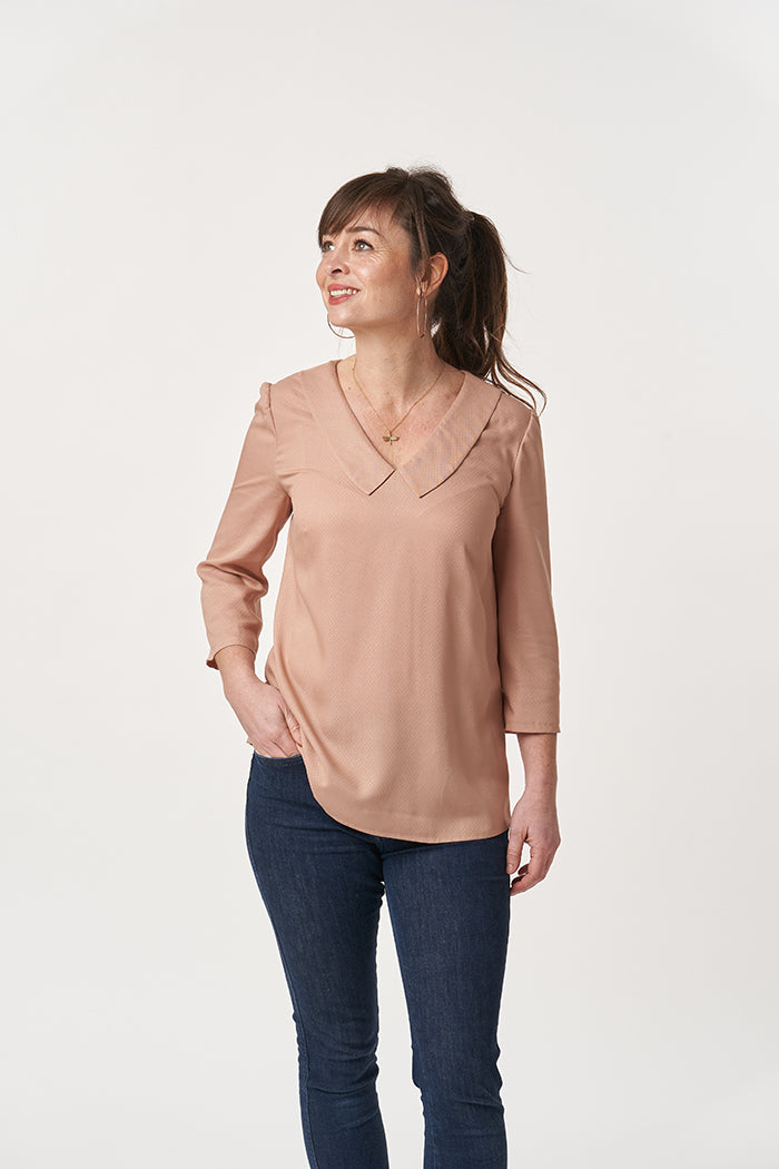 Woman wearing the Susie Blouse sewing pattern from Sew Over It on The Fold Line. A blouse pattern made in cotton lawn, rayon, or crepe fabrics, featuring 3/4 length sleeves, loose fitting bodice, bust darts, v-neckline, and flat collar.