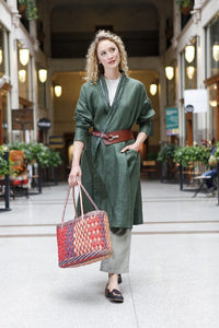 Woman wearing the 254 Swing Coat sewing pattern from Folkwear on The Fold Line. A swing coat pattern made in lightweight linen, gabardine, lightweight denim, soft cotton twill or silk taffeta fabrics, featuring a shawl collar, back yoke with deep pleat, s