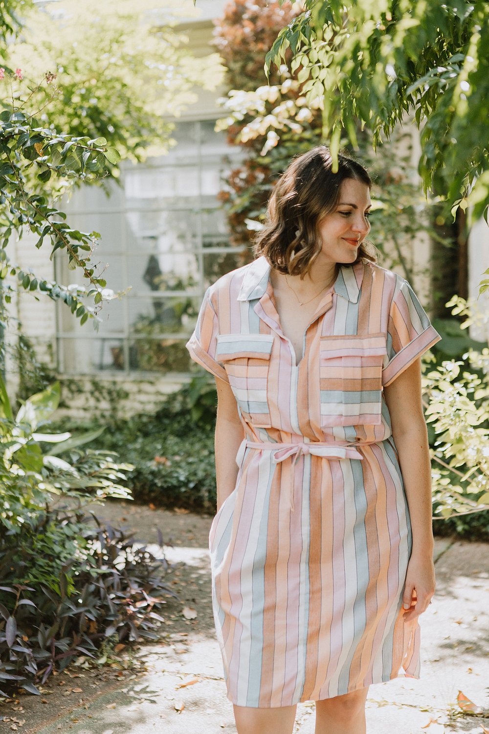 Woman wearing the Sydni Shirt-Dress sewing pattern from Sew To Grow on The Fold Line. A dress pattern made in linen, lawn, medium weight cotton, chambray, gauze, voile, or rayon fabrics, featuring a collar, V-neck, relaxed fit, knee length, front pleated 